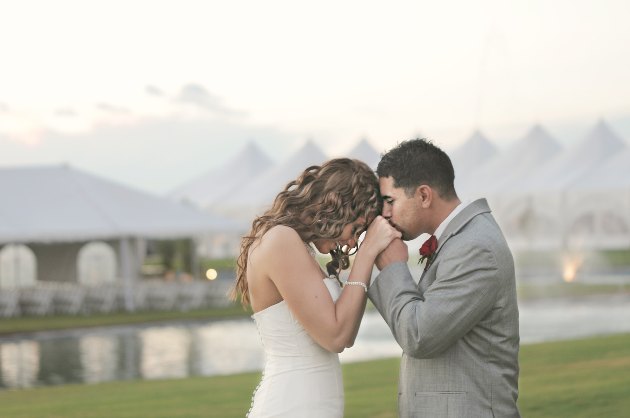 Groom kissing his bride's hand during their wedding portraits
