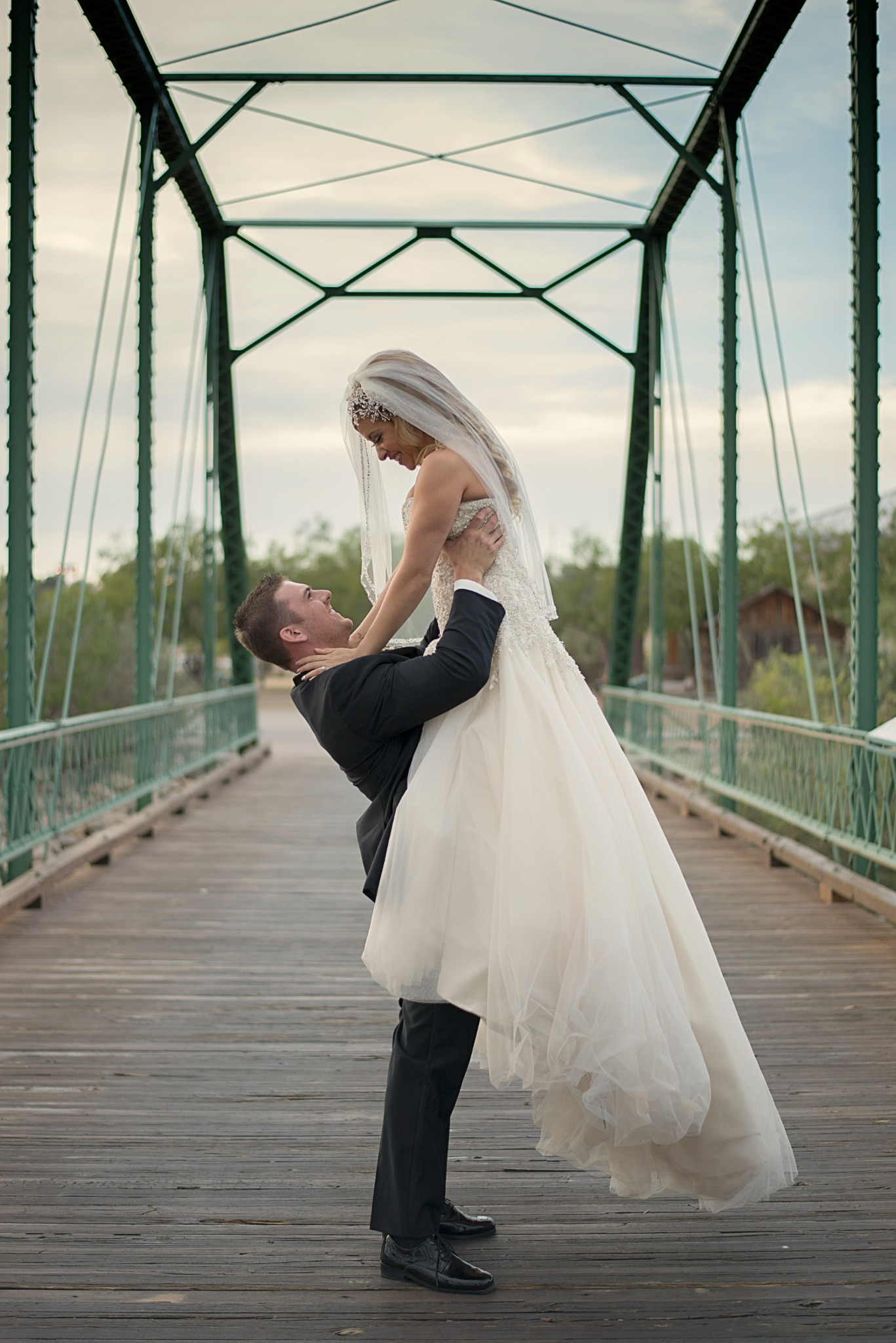 Joyful newlyweds photographed on a historic bridge near Las Cruces